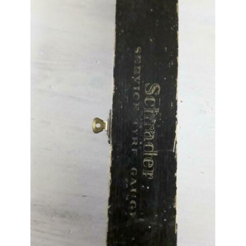 Antieke bandenspanningsmeter in houten doos