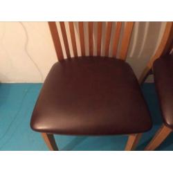 Twee houten keukentafel stoelen met leren zitvlak