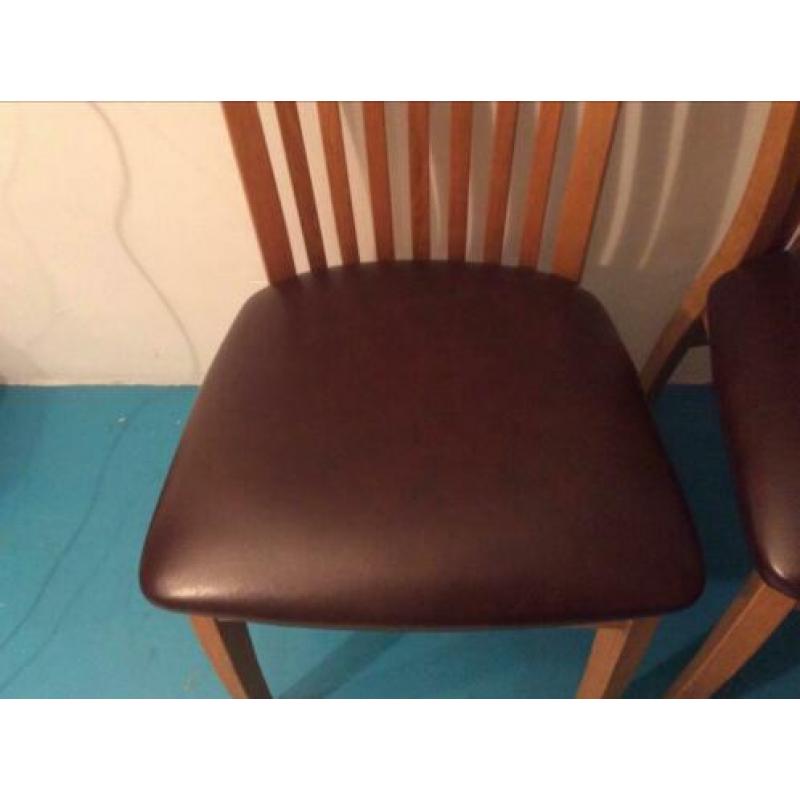 Twee houten keukentafel stoelen met leren zitvlak