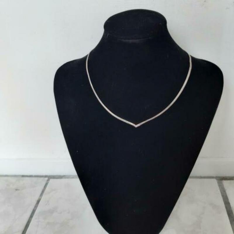Zilveren ketting met platte schakels.