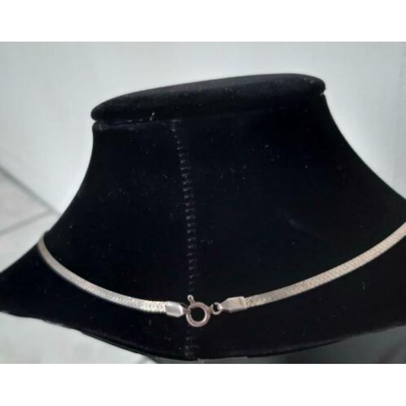 Zilveren ketting met platte schakels.